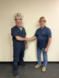ChemPak International Inc. representative (left) and Berndorf Band Group representative (right) shaking hands.
